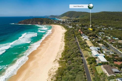an aerial view of a beach with a train at Just Beachy in Boomerang Beach