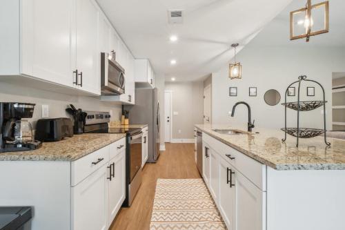 a kitchen with white cabinets and marble counter tops at A pet friendly cozy condo in Traverse City in Traverse City