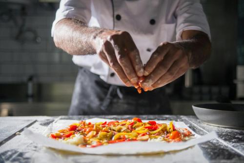 a chef is preparing a pizza on a counter at Charlesworth Bay Beach Resort in Coffs Harbour
