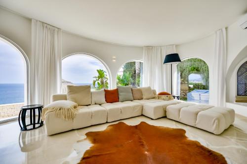 ein Wohnzimmer mit einer weißen Couch und einem großen Fenster in der Unterkunft VERTIGO- Managed by Almarina in Benissa