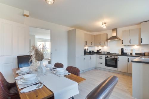 カンタベリーにあるModern Spacious House with Free Parking & Garden - Sleeps 6 - Perfect for Contractors & Familiesのテーブルと椅子のあるキッチンとダイニングルーム