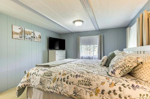 ein Schlafzimmer mit einem Bett und einem Fernseher darin in der Unterkunft Lake Views and Fireside Bliss Cecil Cottage with Yard in Shawano