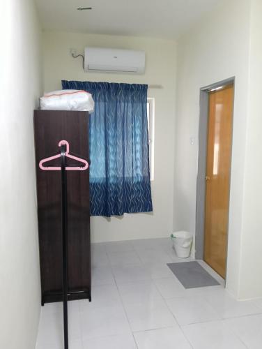 a small room with a bed and a toilet at The Welcome Mat Homestay in Seri Iskandar