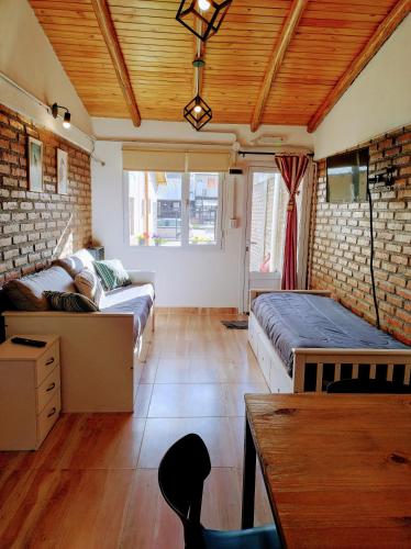 a room with two beds and a couch and a tv at FLAMENCOS Apart in Esquel