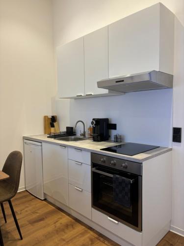 a kitchen with white cabinets and a stove top oven at Luxus Apartment mit Whirlpool in Kiel in Kiel