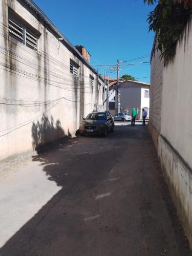 an alley with a car parked next to a building at Kitnets in Contagem