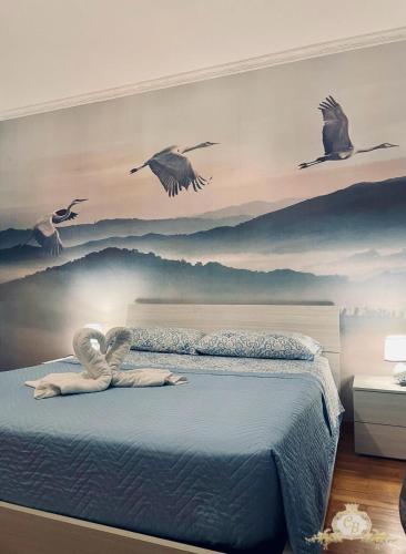 a bedroom with birds flying above a bed at Casa belvedere anzio in Anzio