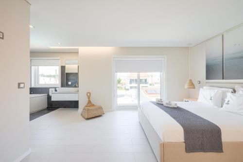 1 dormitorio blanco con 1 cama grande y baño en Dunas Villa, en São Jacinto