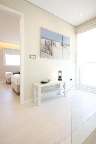 a white living room with a bed and a table at Dunas Villa in São Jacinto