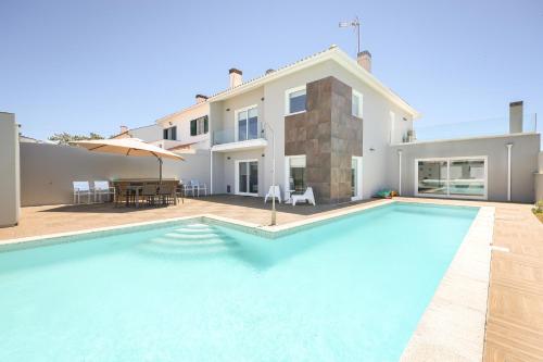 a swimming pool in front of a villa at Dunas Villa in São Jacinto