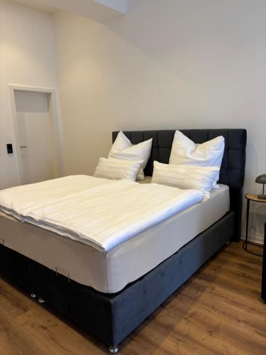 a bed with white sheets and pillows on it at Luxus Apartment mit Whirlpool in Kiel in Kiel