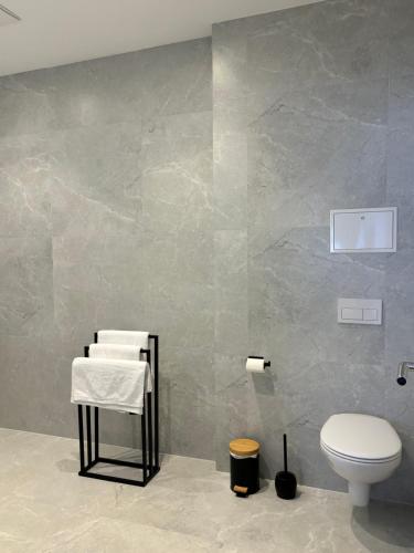 a bathroom with a toilet and towels on a wall at Luxus Apartment mit Whirlpool in Kiel in Kiel