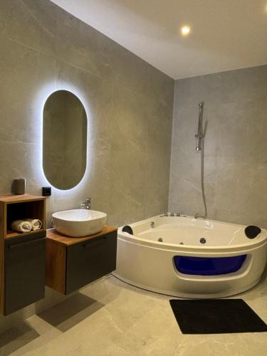 a bathroom with a large tub and a sink at Luxus Apartment mit Whirlpool in Kiel in Kiel