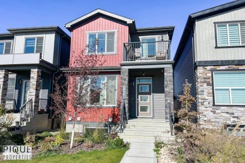 a house with a red door on a street at Modern Retreat - 3 King Beds - Garage - WiFi - Sleeps 10 in Edmonton