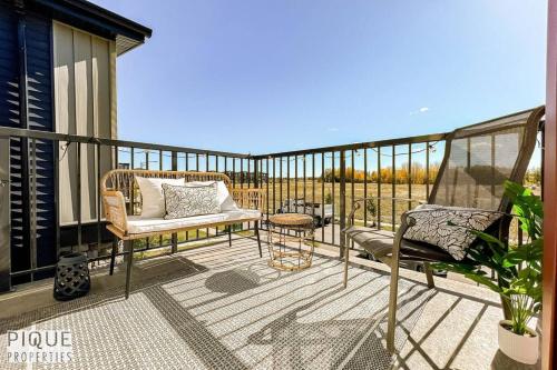 a patio with a couch and chairs on a balcony at Modern Retreat - 3 King Beds - Garage - WiFi - Sleeps 10 in Edmonton