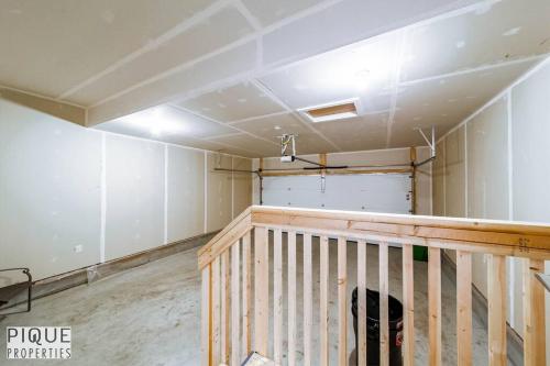 a room with white walls and a wooden staircase at Modern Retreat - 3 King Beds - Garage - WiFi - Sleeps 10 in Edmonton