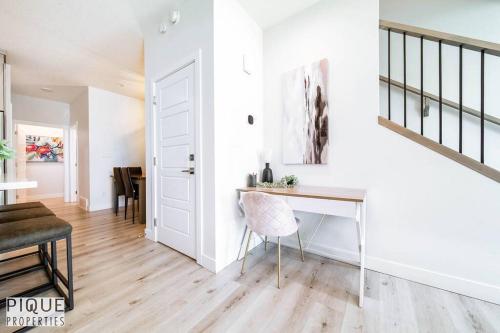 a white room with a desk and a dining room at Modern Retreat - 3 King Beds - Garage - WiFi - Sleeps 10 in Edmonton