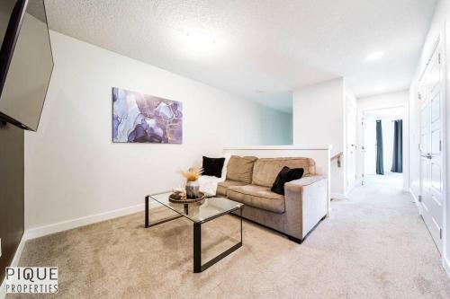 a living room with a couch and a table at Modern Retreat - 3 King Beds - Garage - WiFi - Sleeps 10 in Edmonton