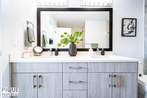 a bathroom with a sink and a mirror at Modern Retreat - 3 King Beds - Garage - WiFi - Sleeps 10 in Edmonton