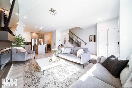 a living room with a couch and a table at Modern Retreat - 3 King Beds - Garage - WiFi - Sleeps 10 in Edmonton