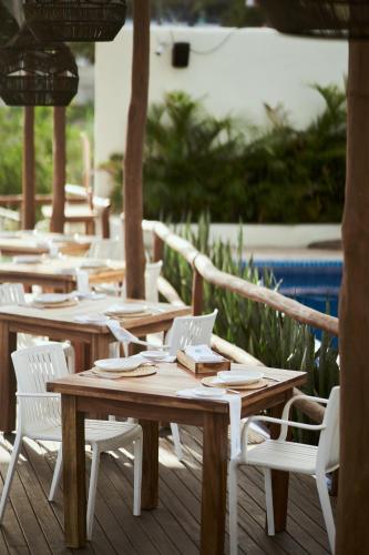 a row of wooden tables and chairs with a laptop at Hotel Ysuri Bucerias in Bucerías