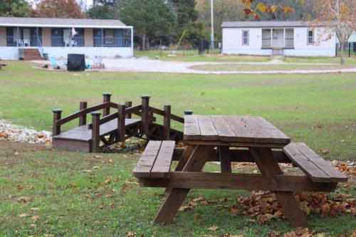 a wooden picnic table and bench in a field at DazeOFF Too Suite 7 - Pet Friendly Suite by The Lodges at Fossil Creek in Shay