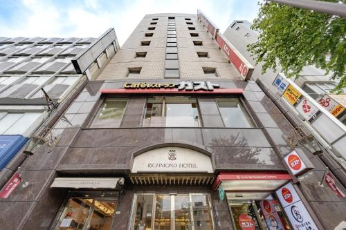 a tall building with a sign on the front of it at Richmond Hotel Tokyo Mejiro in Tokyo