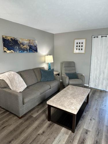 a living room with a couch and a table at Cozy condo with no stairs, and arcades! 5 beds in Branson