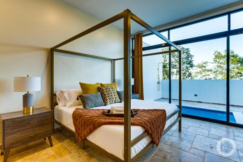 a bedroom with a canopy bed and a large window at Las Haciendas in San Ignacio