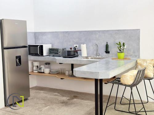 a kitchen with a counter and a refrigerator at Nomad Living CR Tárcoles in Tarcoles