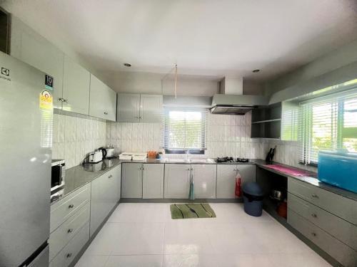 a kitchen with white cabinets and white appliances at My PoolVilla Cha am in Cha Am