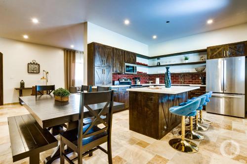 a kitchen with a wooden table and blue chairs at Las Haciendas in San Ignacio