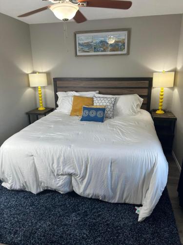 a bedroom with a large white bed with two lamps at Cozy condo with no stairs, and arcades! 5 beds in Branson