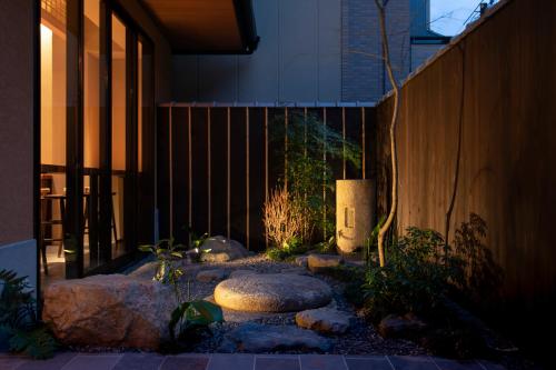 a garden with rocks in front of a building at Hotel Ethnography Kiyomizu Gojo in Kyoto