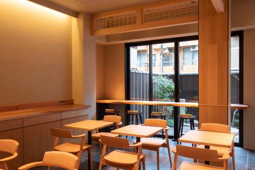 a restaurant with wooden tables and chairs and a window at Hotel Ethnography Kiyomizu Gojo in Kyoto