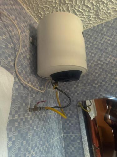 a white light on a wall with a cord at Debora Guest House in Freetown