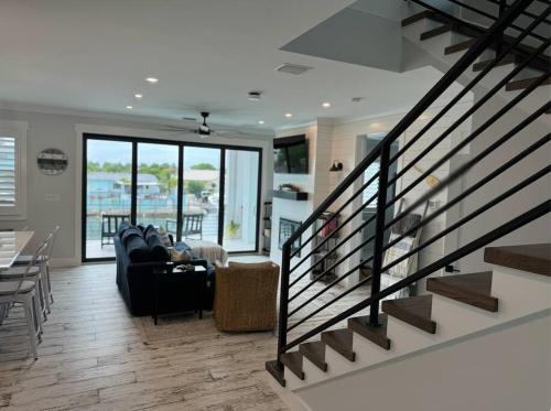 a living room with a black couch and a staircase at Newly built home in Cudjoe Key in Cudjoe Key