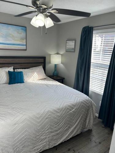 a bedroom with a bed and a ceiling fan at Beautiful condo-no stairs, and arcade games! 5bed in Branson