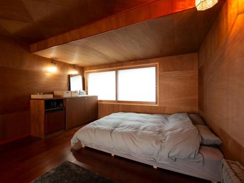 a bedroom with a bed in the corner of a room at Wadami384 in Matsue