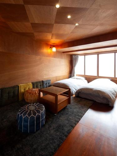 a bedroom with two beds and a table in it at Wadami384 in Matsue