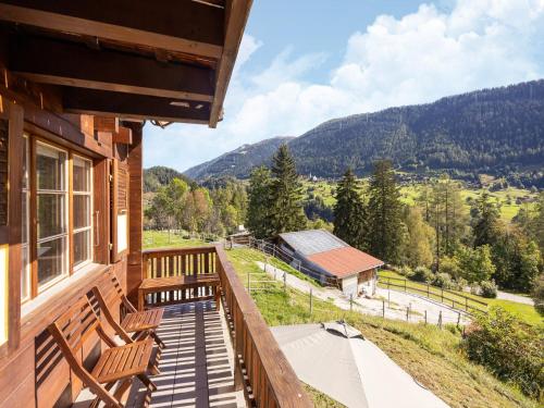 a porch of a cabin with chairs and a view of the mountains at Chalet Verrel near Aletsch Ski Gondolas in Fiesch