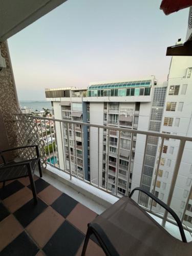 a balcony with a chair and a view of a building at Isla Verde Modern Apartment with Pool in San Juan