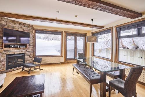 a dining room with a glass table and a fireplace at Niseko Central Houses and Apartments in Kutchan