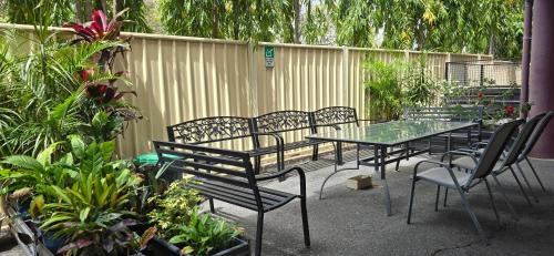 a patio with tables and chairs and plants at Archer Park Motel in Rockhampton