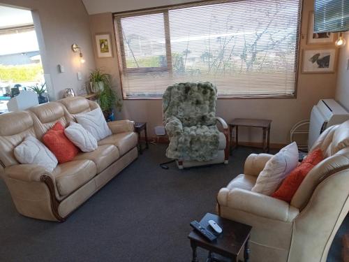 a living room with two couches and a chair at Clutha Views in Balclutha