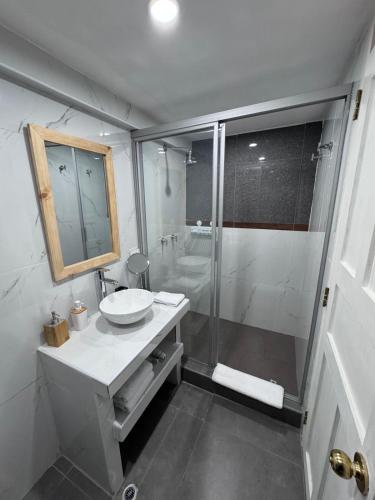 a white bathroom with a sink and a shower at CASA CRISTOBAL Siete Cuartones in Cusco