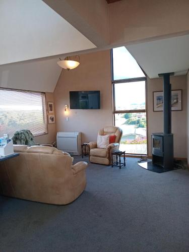 a living room with a couch and a fireplace at Clutha Views in Balclutha