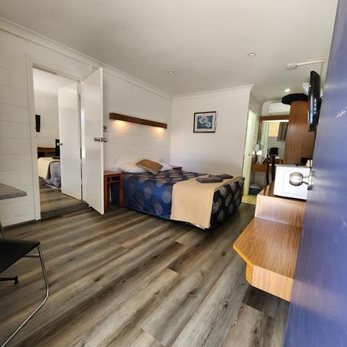 a hotel room with a bed and a desk at Byer Fountain Motor Inn in Holbrook