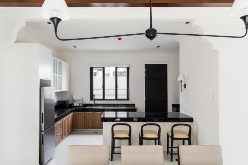 a kitchen with a black counter and bar stools at Bayandati Resort in Bataan