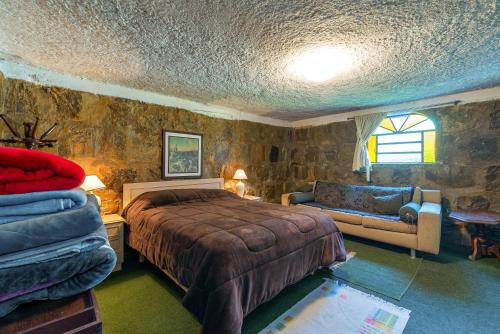 a bedroom with a bed and a couch at Casa Tissot- 5 Quartos no Centro de Gramado in Gramado